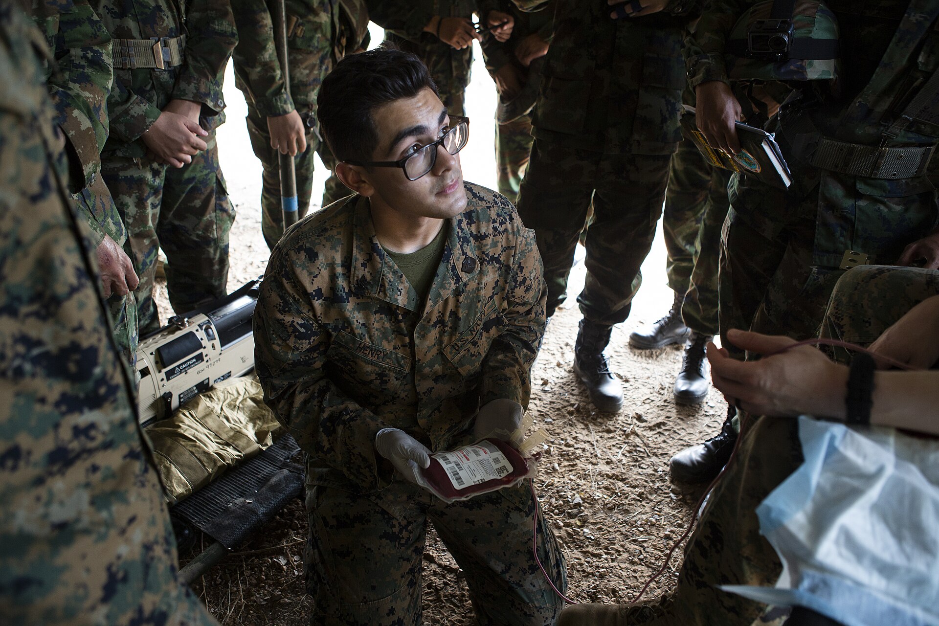 A clinician handling a blood bag during transfusion training